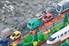 An illustration which on the top half shows a polluted deforested area and a polluted road, and on the bottom half, a clean road with electric cars, green spaces and people cycling