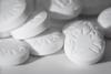 Macro photograph of white tablets marked with the word aspirin