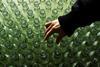 A hand examines clear glass bottles
