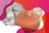 Photo of orange fizzy drink in a glass jug with a wooden ruler 