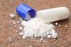 Photo of white powder spilling out of a drug capsule