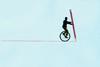 An illustration showing a silhouette man on an unicycle, balancing using a giant pencil