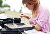 Young, female archaeologist sifting through soil