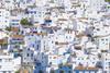 A photo of houses painted white on the side of a hill