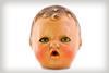 A photo of an old plastic doll's head