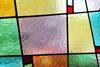 A close-up, full-frame photograph of multicoloured stain glass panels