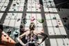 A photo of a woman planning her route up an indoor rock climbing wall