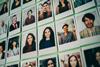 Many portrait polaroid photos arranged on a wall