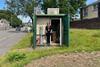 Emma is standing in an outdoor office with equipment inside. 