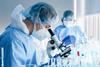 Photo of a laboratory scientist looking into a microscope
