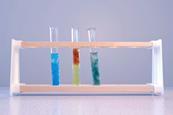 A photograph of three test tubes in a test tube rack, each containing a different colour of precipitate including copper hydroxide, iron(III) hydroxide and iron(II) hydroxide