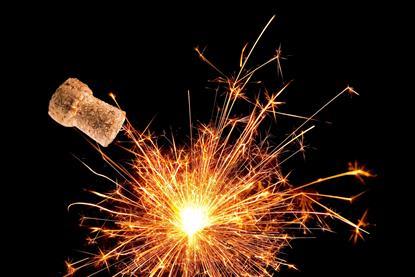 An image of a cork flying from an explosion effect created by a sparkler against a black background