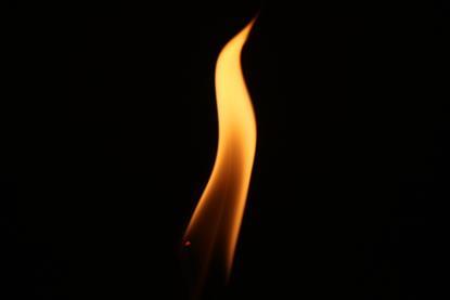 A single orange flame against a black background