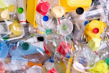 A full-frame photograph of a heap of plastic bottles and containers for recycling