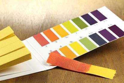 A photograph showing a booklet of detachable strips of universal indicator paper, with a colour chart for comparison