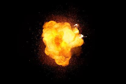 A yellow-orange explosion against a black background, surrounded by sparks
